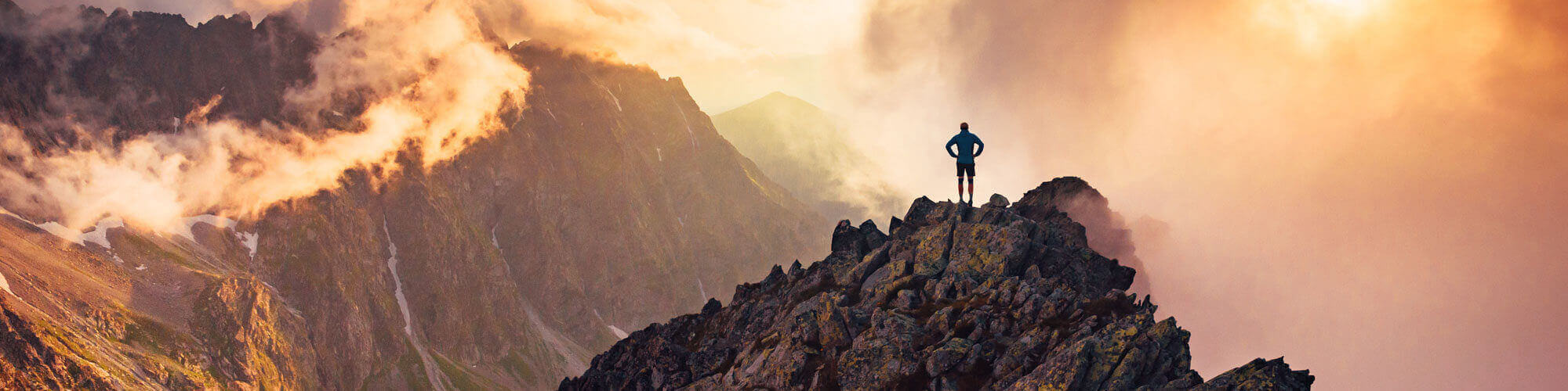 Man Standing On Top Of Mountain